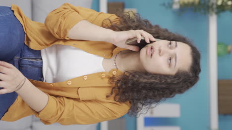 Vertical-video-of-Young-woman-getting-bad-news-on-the-phone-gets-upset.